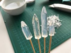 three crystal sticks on a green cutting board