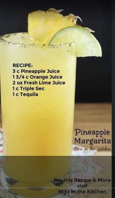 a pineapple juice is in a tall glass with a lime slice on the rim