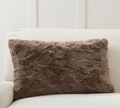 a brown pillow sitting on top of a white couch