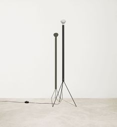 two floor lamps with one light on the ground