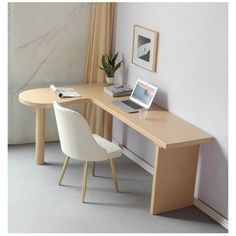 a desk with a laptop on it in front of a window and a chair next to it