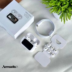 an apple watch and earbuds are sitting on a table next to a plant