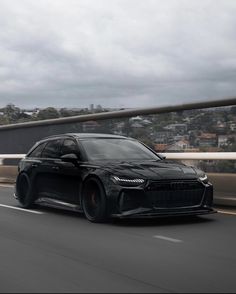 a black sports car driving down the road