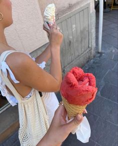 a woman is holding an ice cream cone in her hand