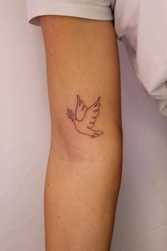 a woman's arm with a small dove tattoo on the left side of her leg