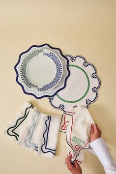 a person holding napkins next to plates on a table