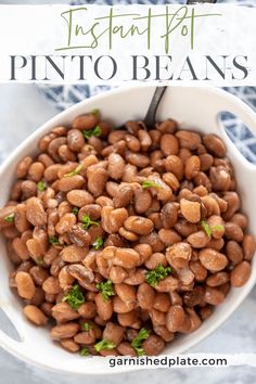 a white bowl filled with pinto beans and garnished with parsley on top