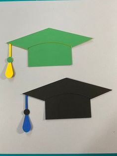 two graduation hats, one with a tassel and the other with a blue tassel