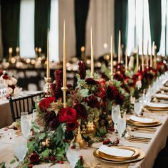 the table is set with candles, plates and napkins for an elegant christmas dinner