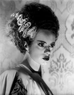 a black and white photo of a woman with curly hair in a bun hairstyle