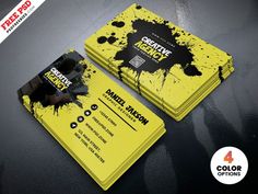 two yellow business cards with black ink splatters on them, one is for creative design