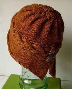 a brown knitted hat sitting on top of a glass vase