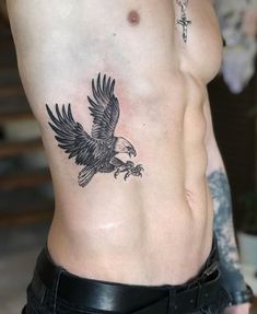 an eagle tattoo on the side of a man's chest is shown in this image