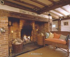 a living room with a fire place and wicker furniture in front of the fireplace