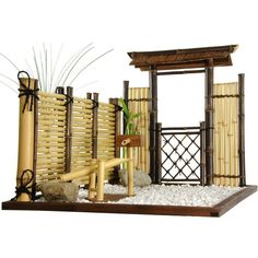 a bamboo fence with plants and rocks in the ground next to it on a white background