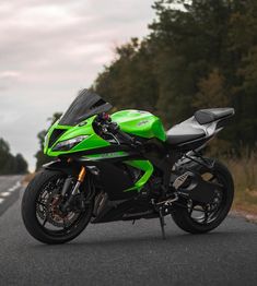 a green motorcycle is parked on the side of the road