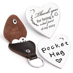 two heart shaped key chains with tags attached to them