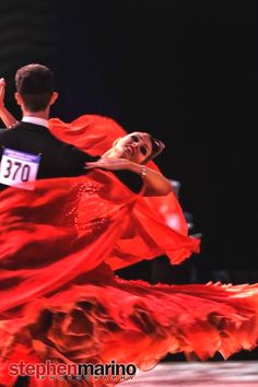 a man and woman dance in flamenco dresses at the end of a competition with their arms around each other