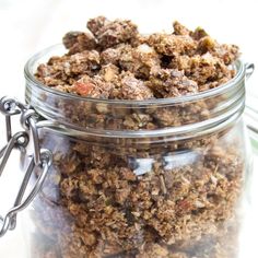 a glass jar filled with granola sitting on top of a table