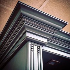 the corner of a building with an ornate design on it's front door frame