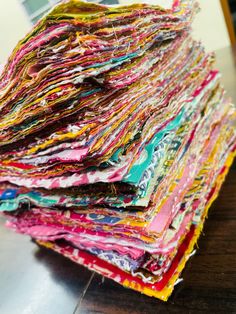 a pile of colorful fabric sitting on top of a wooden table