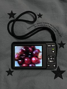 a digital camera sitting on top of a bed next to star shaped stars and the words photo that takes photographs