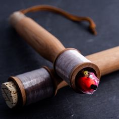 a close up of a wooden object on a black surface with a red bird painted on it