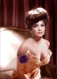 an old photo of a woman sitting on a couch wearing a dress with flowers in her hair