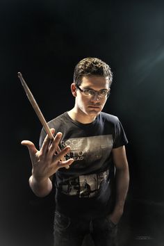 a man with glasses holding a wand in his hand