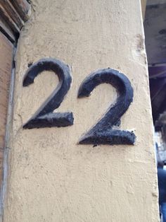 the number 22 is painted on the side of a building with black letters and numbers