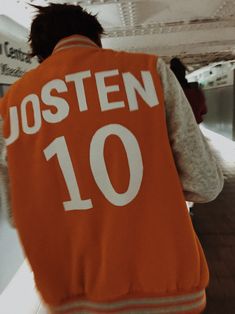 a person wearing an orange vest with the number ten written on it in white letters