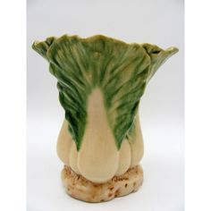 a green and white vase sitting on top of a table