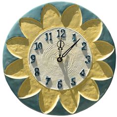 a blue and gold clock with numbers on it's face in the shape of a sunflower