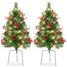 two christmas trees with lights and decorations on them are shown in front of each other