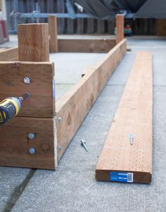 a drill is laying on the ground next to some wooden planks and screws