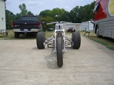 a motorcycle is parked in the driveway next to a trailer and camper behind it