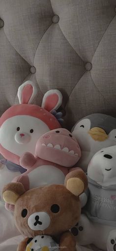 a pile of stuffed animals sitting on top of a bed