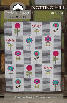 a quilted wall hanging with flowers on it