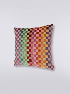 a multicolored pillow sitting on top of a white wall