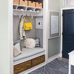 a white bench sitting under a window next to a coat rack