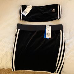 two black and white adidas shorts on top of a bed with a price tag