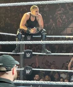 two women sitting in the middle of a wrestling ring