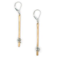 two pairs of silver and gold earrings on a white background, one with a wooden stick in the middle