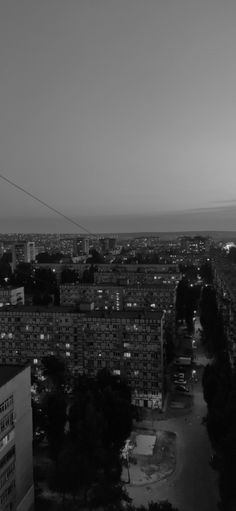 black and white photo of city at night with street lights in the foreground, from above