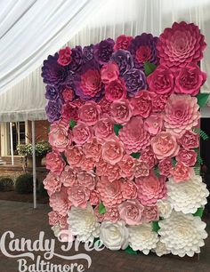 large paper flowers arranged on top of each other in different colors and sizes for a wall decoration