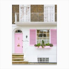 a pink door and window in front of a white house