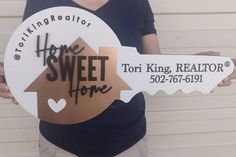 a person holding a sign that says home sweet home