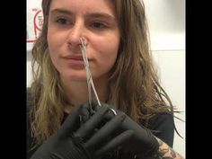 a woman with long hair and black gloves is holding scissors in her right hand while looking at the camera