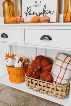 pumpkins and other decorations on a white shelf