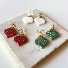 six different colored heart shaped earrings on a marble tray